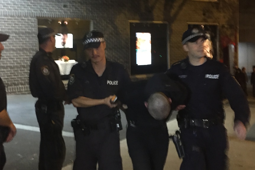 A protester being taken away by police during the protest against Pauline Hanson in Ultimo.