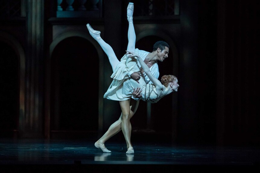 Two ballet dancers playing Romeo and Juliet, the male dancer holding the female dancer on stage