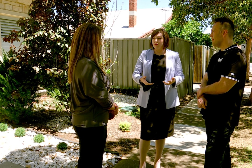 A politician talking to two members of the public