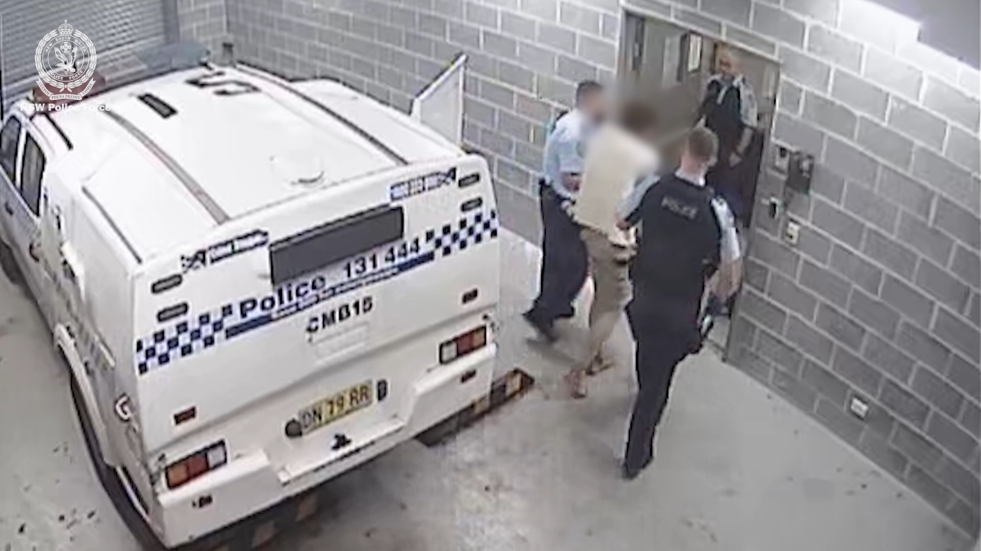Un hombre, con el rostro borroso, sube a un coche de policía y los agentes lo llevan a prisión.