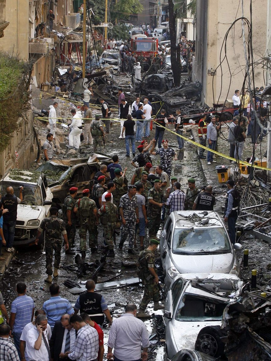 Security forces and rescue workers gather at the site of an explosion in Beirut
