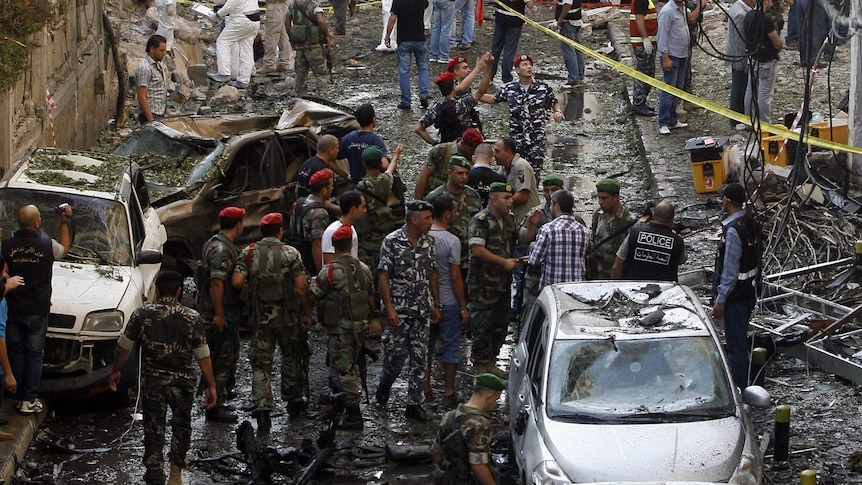Security forces and rescue workers gather at the site of an explosion in Beirut