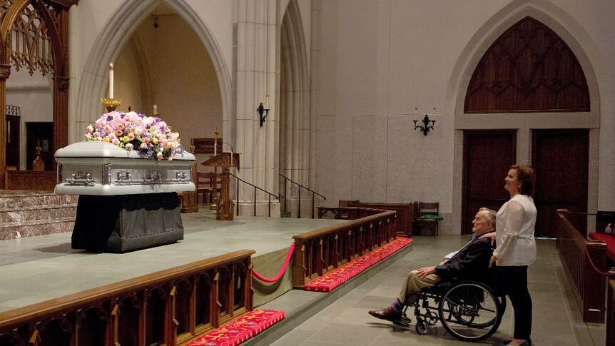 Former President George HW Bush looks at the casket of his wife former first lady Barbara Bush