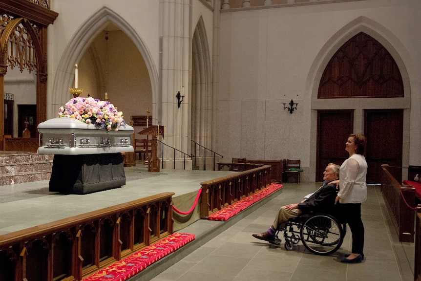 Former President George HW Bush looks at the casket of his wife former first lady Barbara Bush