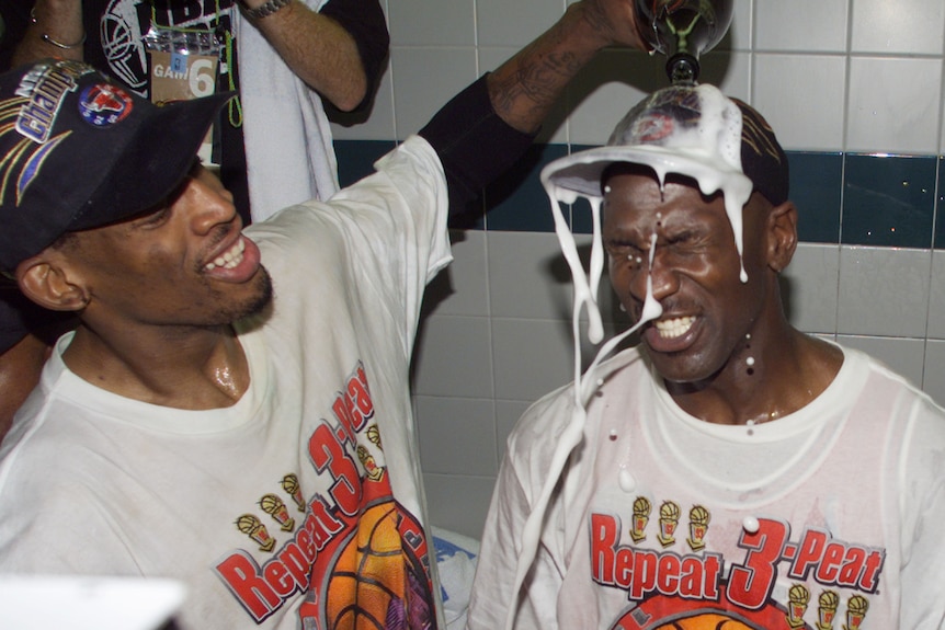 Dennis Rodman pours champagne on the head of Michael Jordan