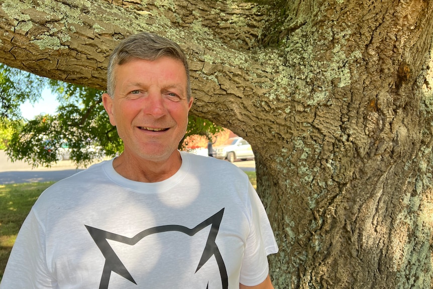 A man with short dark grey hair smiles at the camera.