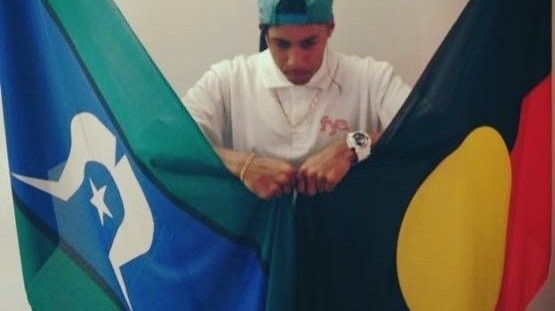 Noongar man Derek Nannup with the Australian Aboriginal and Torres Strait Islander flags.