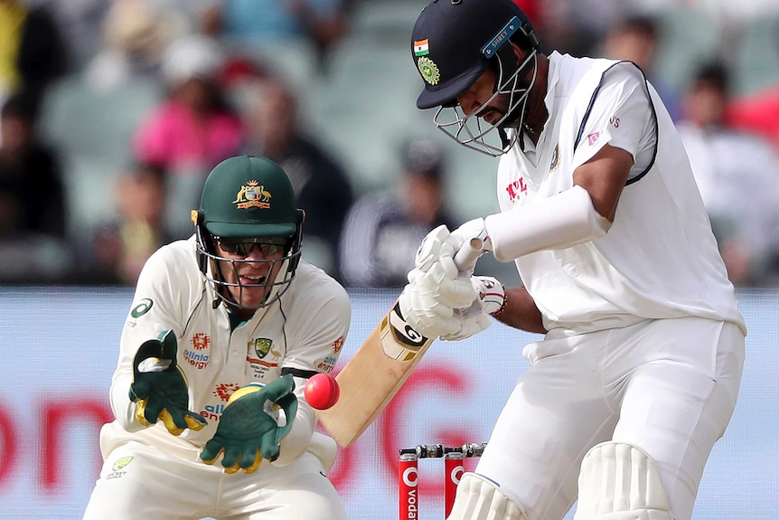 Cheteshwar Pujara plays a late cut shot with Tim Paine standing ready to catch the ball