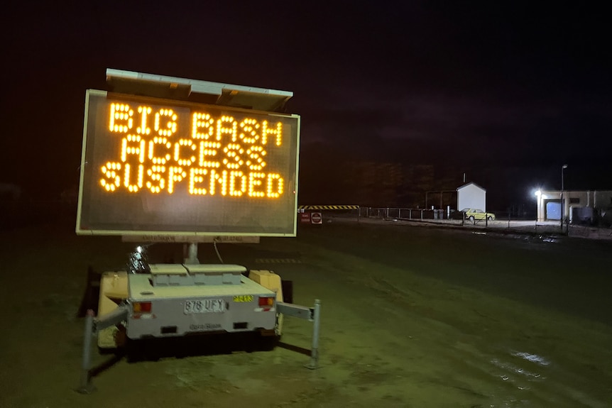 An electronic sign displaying Big Bash Access suspended, darkness in background.