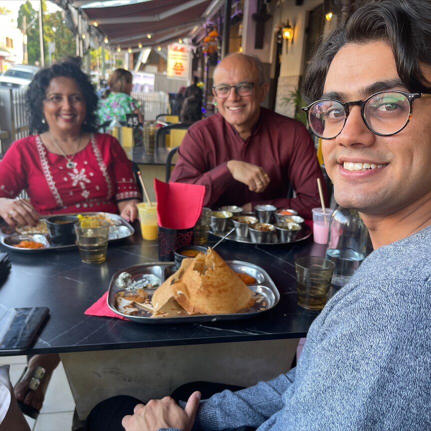 A young man with his parents at a restaurant