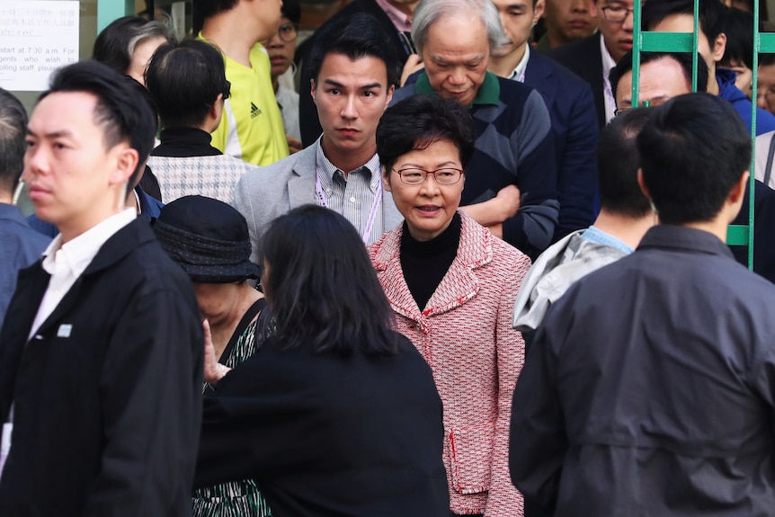 Hong Kong leader Carrie Lam is surrounded by people after voting.