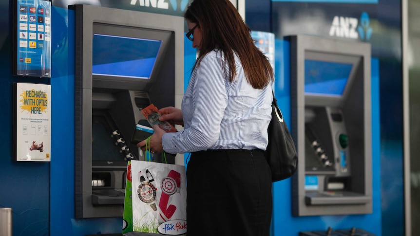 A woman uses an ATM