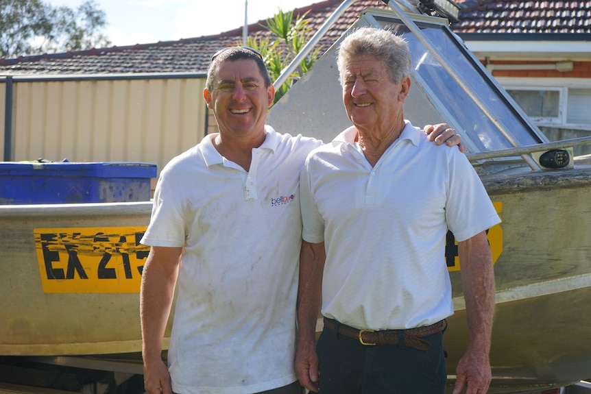 Photo of Damien Bell and his father Aiden Bell in front of his fishing boat.