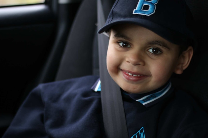 Headshot Cameron Lonsdale who is smiling, sitting with his seatbelt on in a car