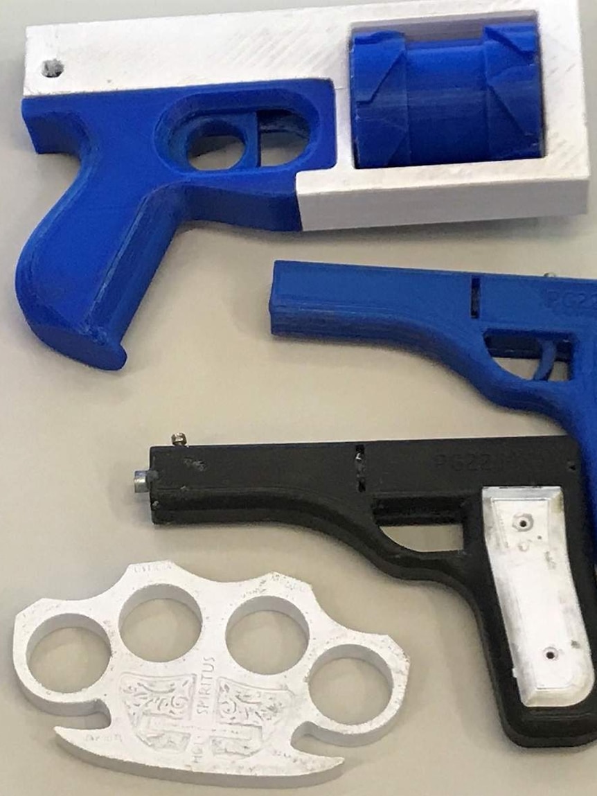 Two blue and one black and white handgun and a knuckleduster from a 3D printer found by police on the Sunshine Coast.
