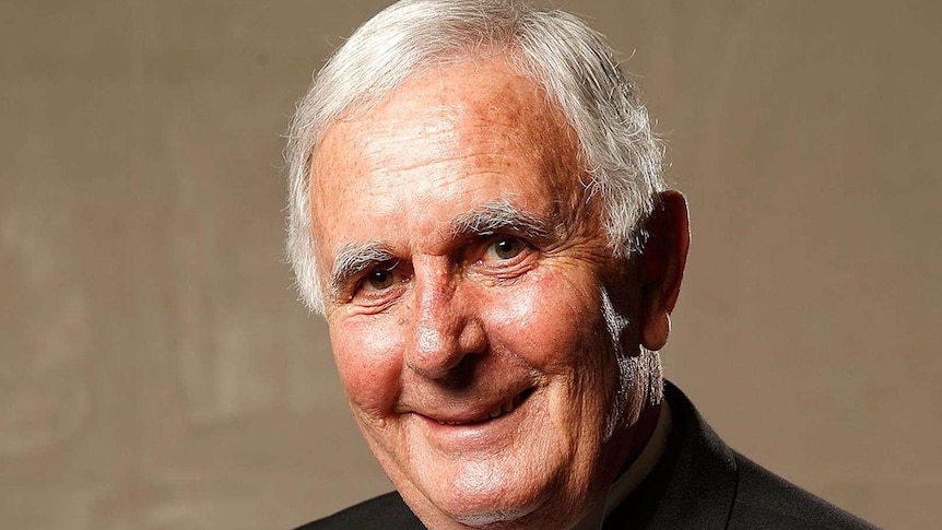 An elderly man wearing a black tuxedo and a bowtie