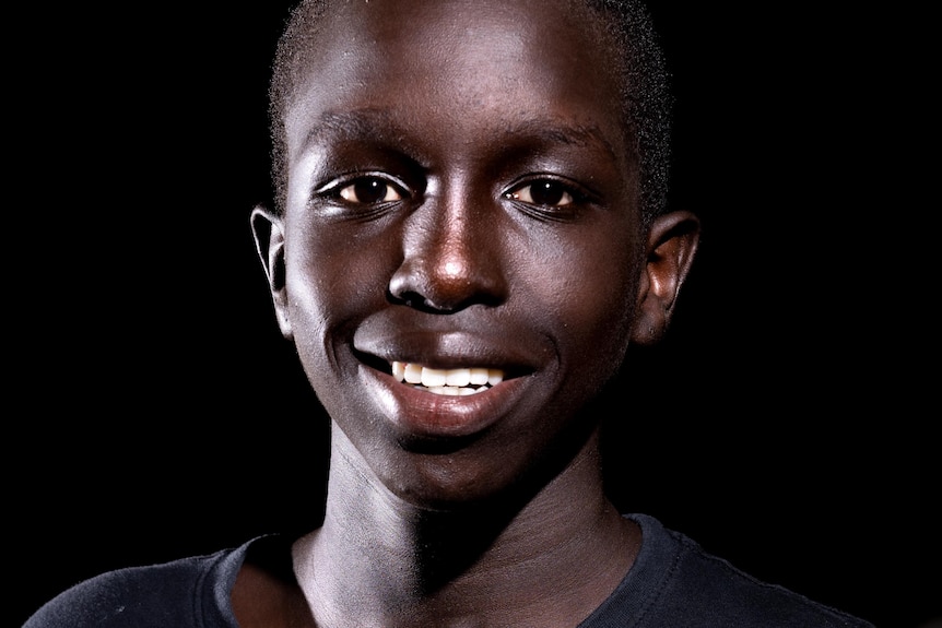 Adelaide teenager Anai Lual holds a basketball.