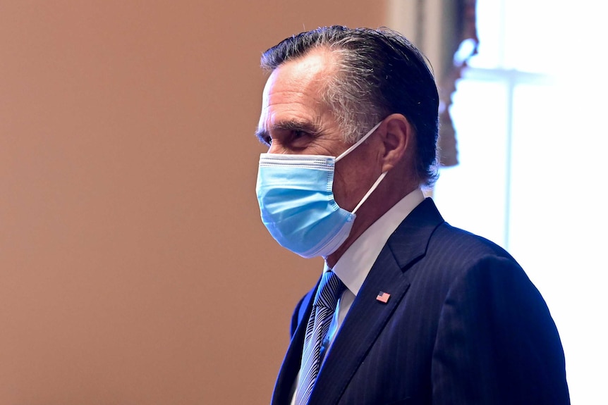 Mitt Romney wearing a mask and a suit and tie looking left of screen