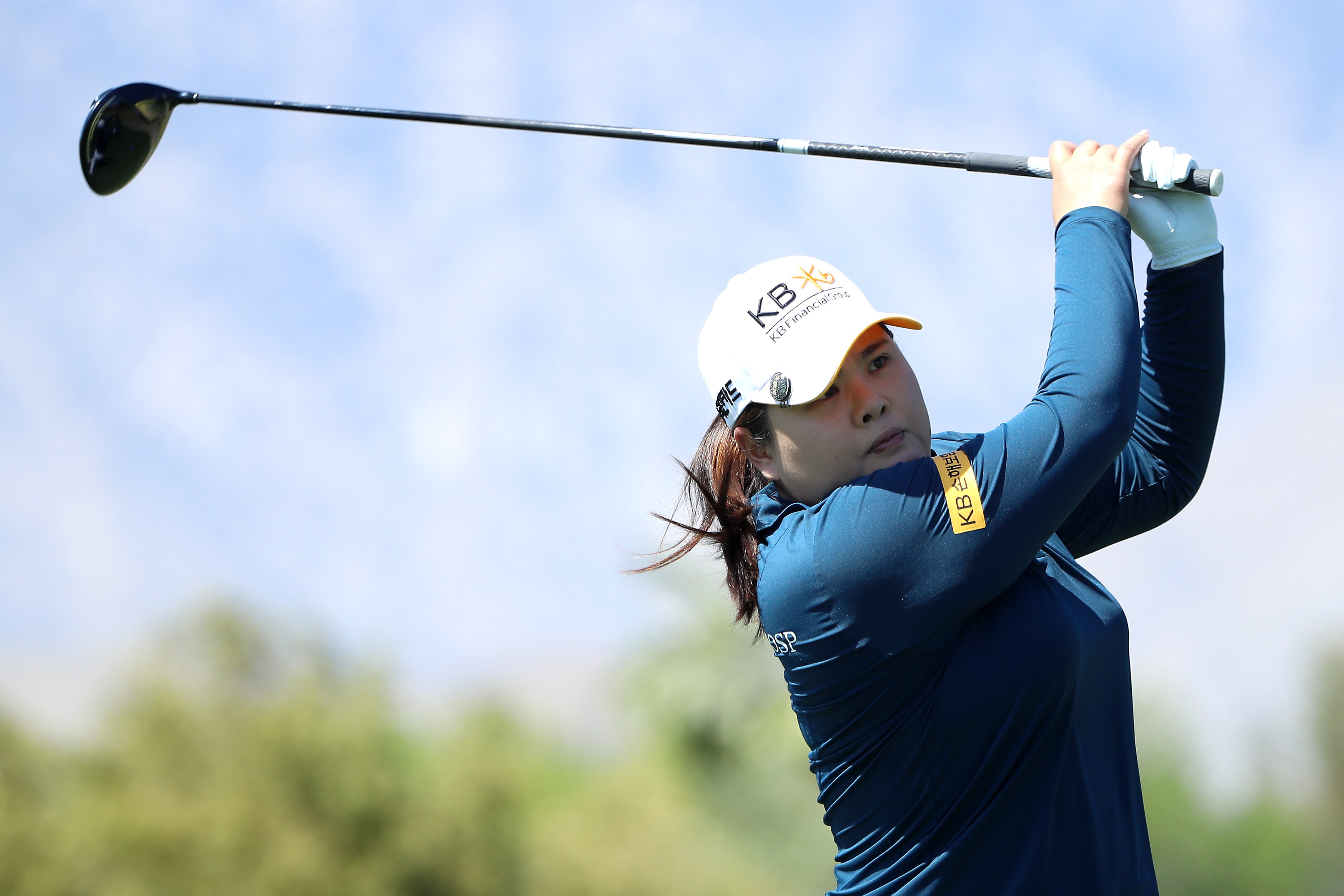 Close up of Inbee Park of Korea teeing off on the fourth. She wears a long sleeve blue top and white hat with white glove