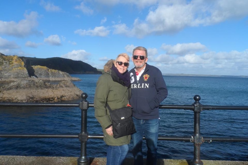 Robyn and Col Manning in the UK standing in front a body of water