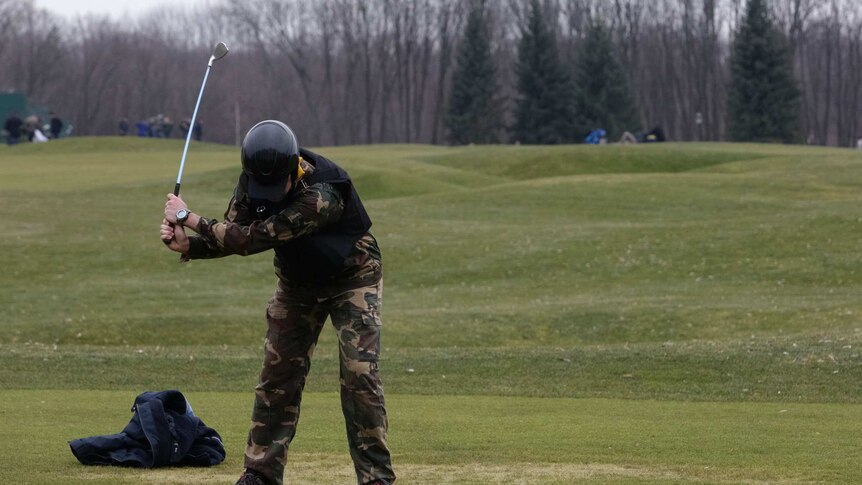 A man plays golf in the grounds at Ukraine ex-leader Yanukovich's residence