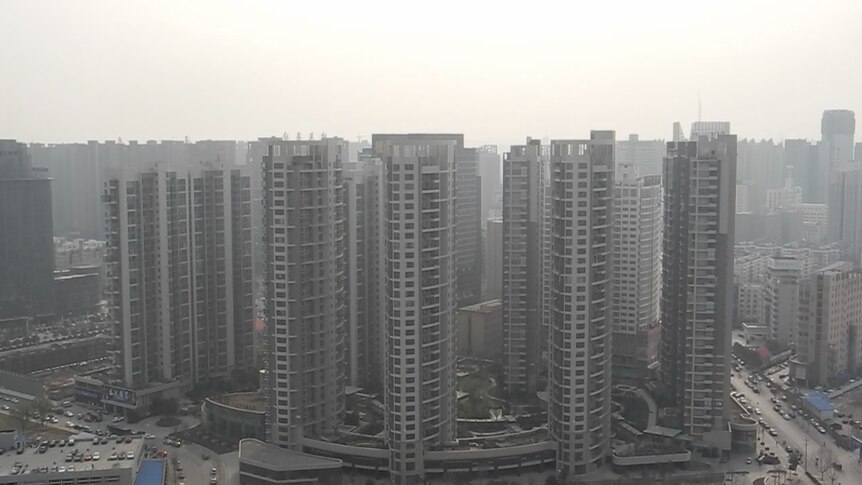 A cluster of apartment towers in a smoggy setting.