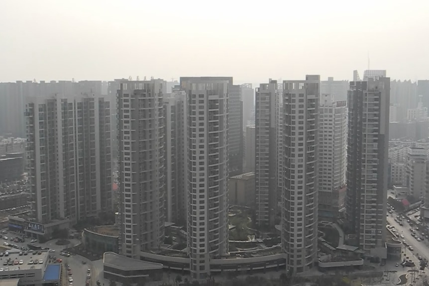 A cluster of apartment towers in a smoggy setting.