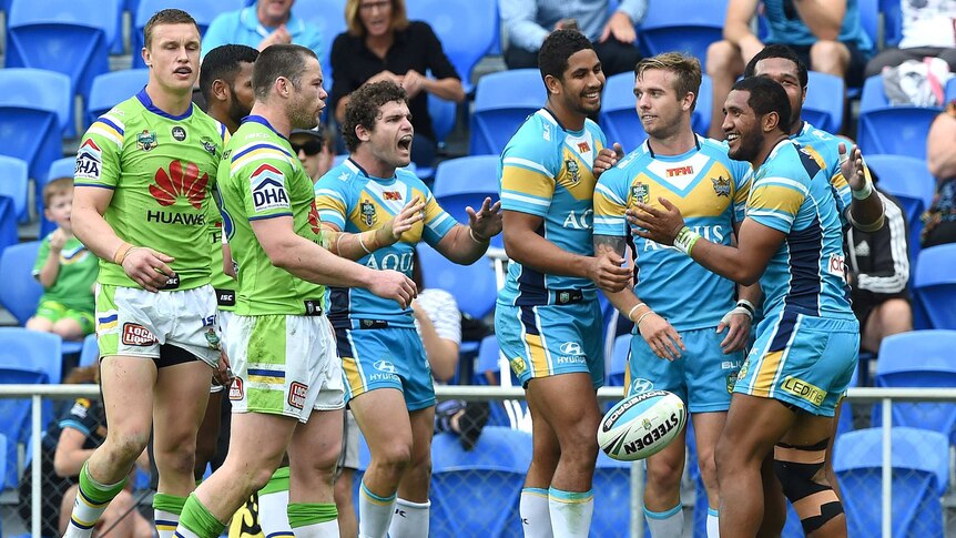 Titans players celebrate a try against the Raiders