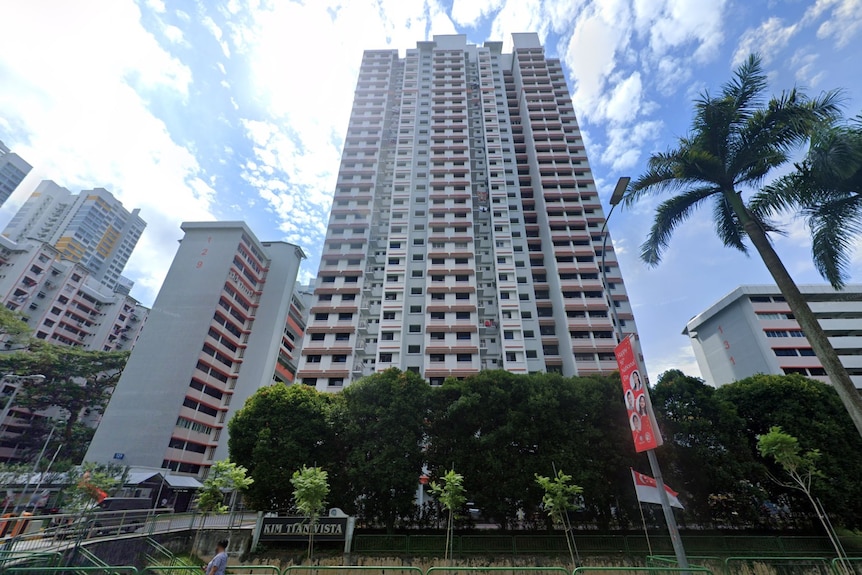 A street view looking up at a tall public housing block in Singapore. 