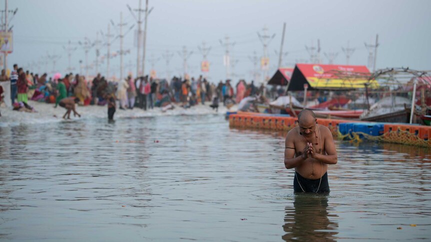 A man prays at the shore of the Ganges river.