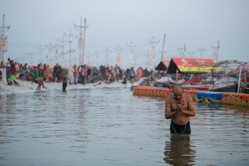 A man prays at the shore of the Ganges river.