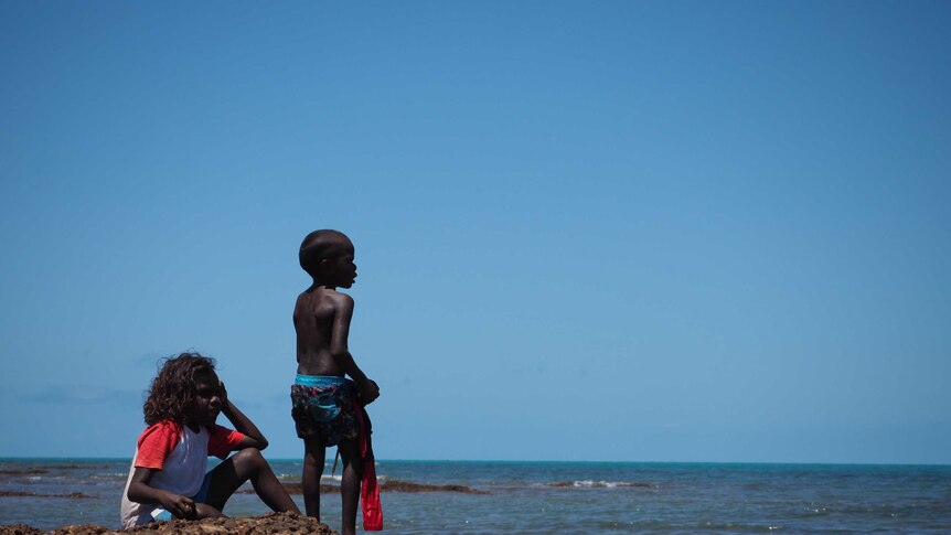 Indigenous boy stands by the ocean