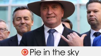 Wearing an akubra, Mr Joyce stands in front of colleagues.