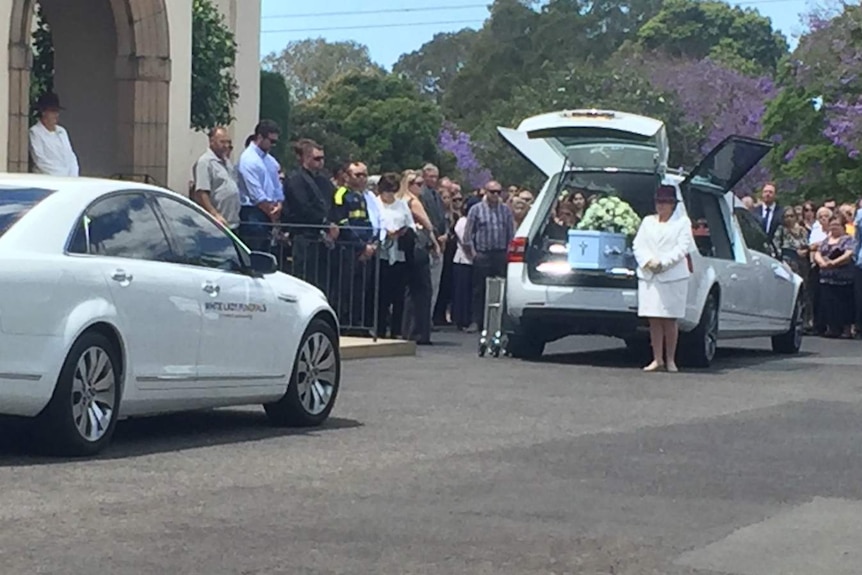 a coffin can be seen in the back of a hearse.