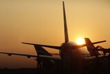 Grounded: The sun sets behind planes at Heathrow airport