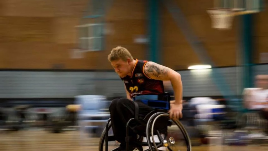 Graeme Docking races in his wheelchair during a basketball match