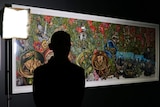 A silhouetted figure in front of the painting.