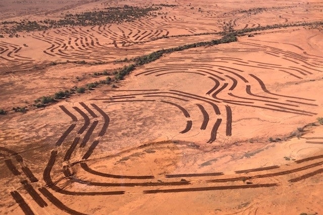 An aerial view showing red dirt and tractor marks where Barry Turner has applied the principles of EMU