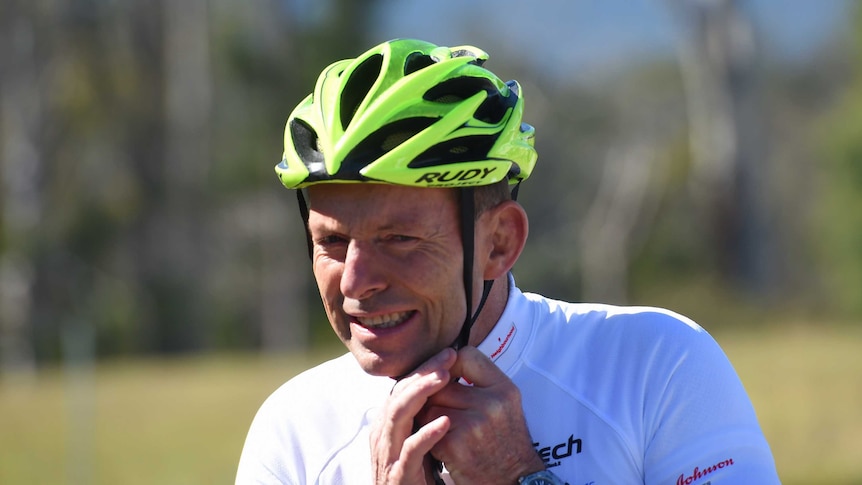 Former prime minister prepares to ride, adjusts his yellow helmet in the Pollie Pedal in 2015.