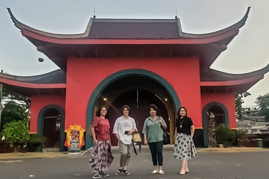 Tepi Mumpuni with 3 of her friends stand in front of a Chinese Temple