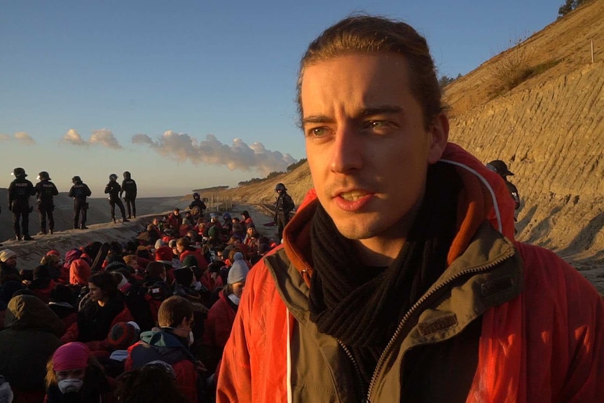 Daniel Hofinger stands in front of other activists disrupting a coal mine.