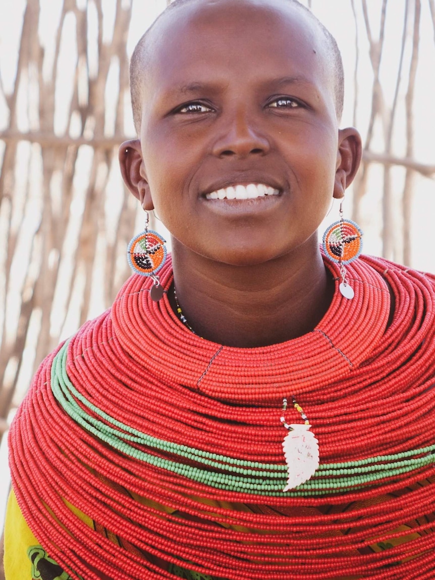 A woman in the Kenyan community of Unity wears colourful beadwork and long earrings.