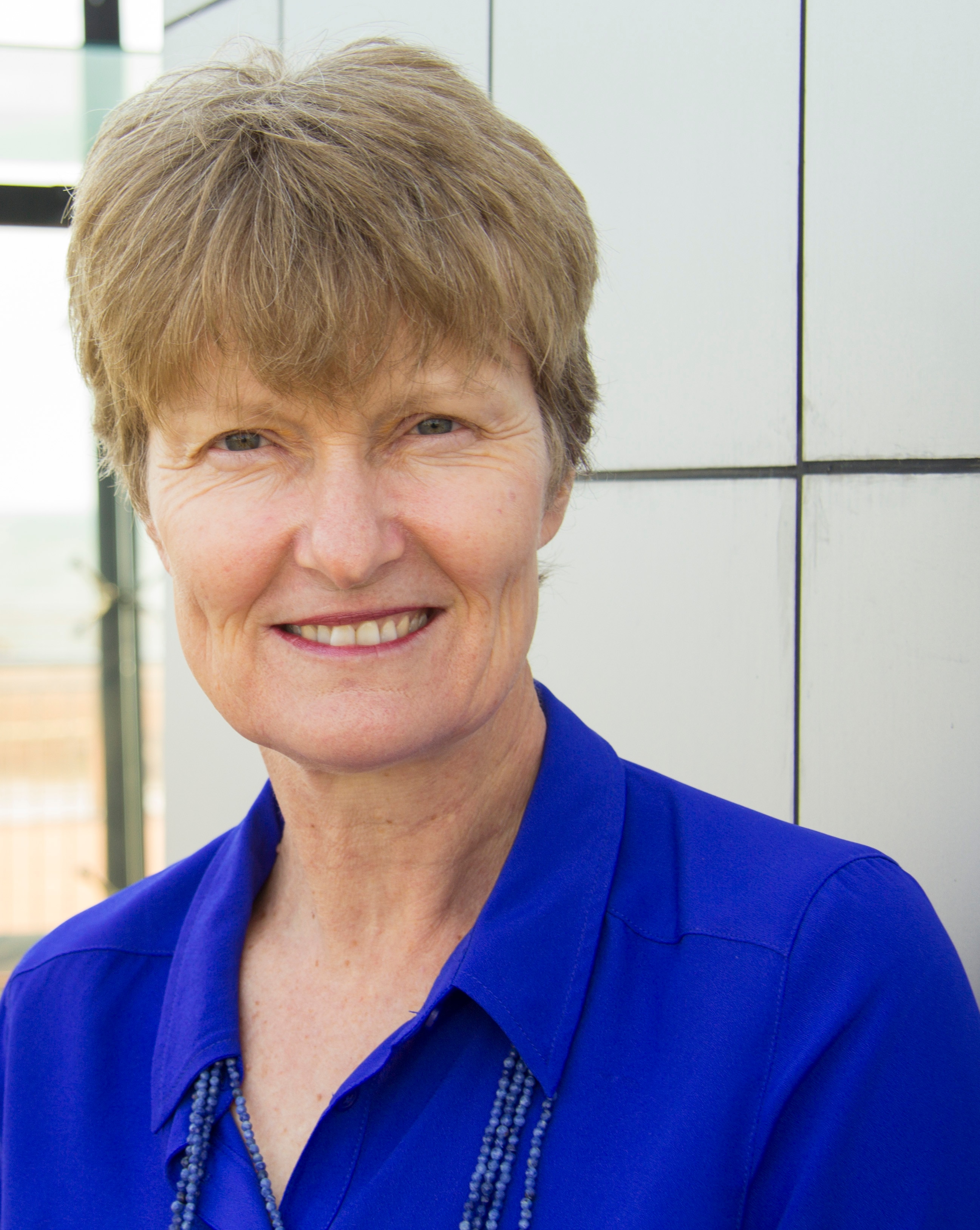 A woman in a blue shirt posing for camera