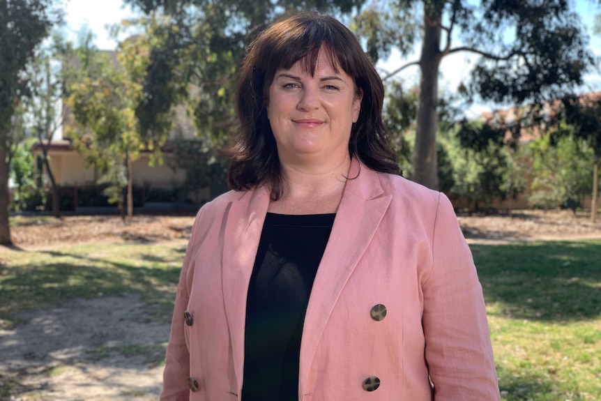 Bronwen Clark standing outdoors wearing a pink jacket.