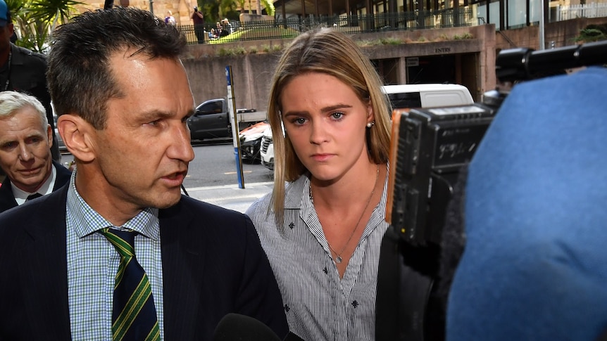 Australian swimmer Shayna Jack looks distressed amid a media pack.