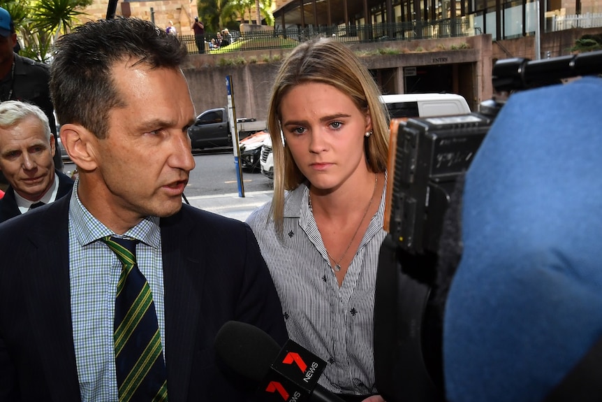 Australian swimmer Shayna Jack looks distressed amid a media pack.