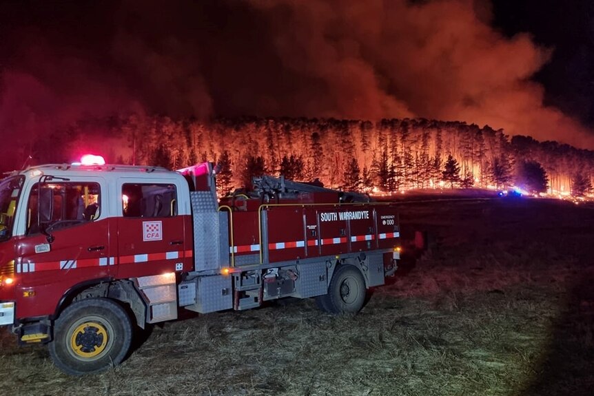 Fire truck in front of large bushfire.