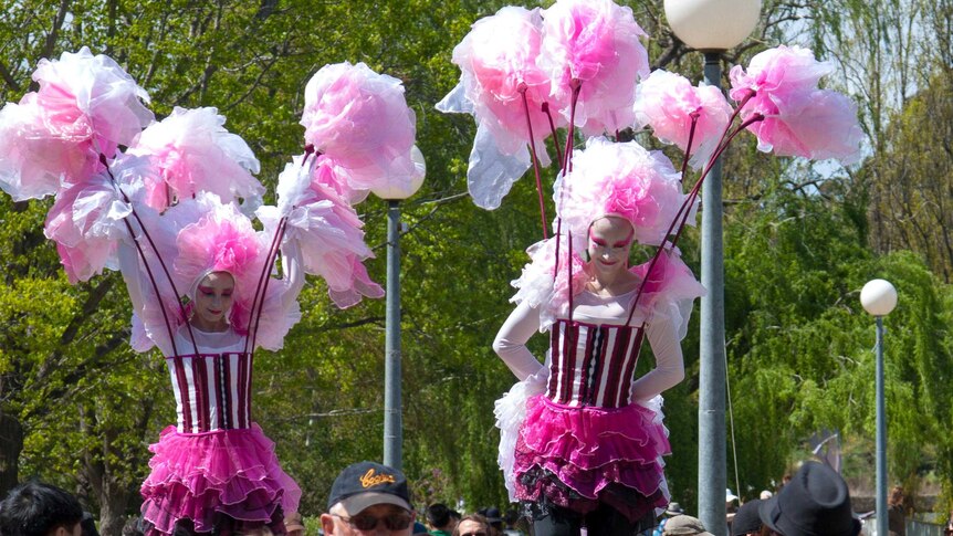 Entertainers on stilts walk through the crowd at Floriade in Canberra.