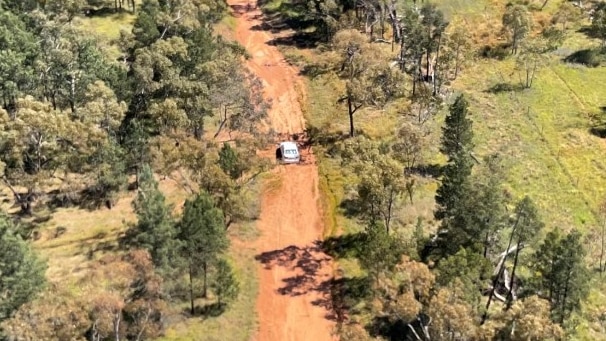 Aerial view of car stuck in sand road