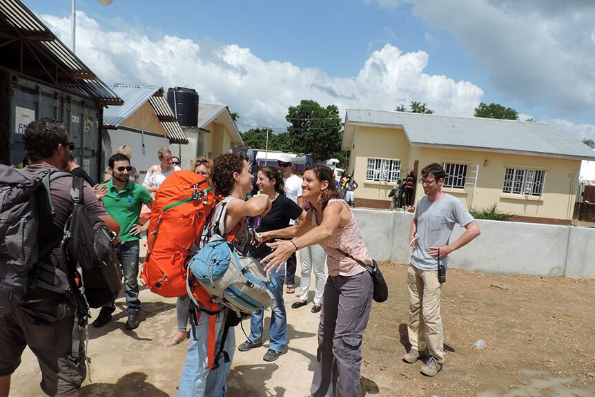 Two volunteers give each other an 'Ebola hug' as they depart Sierra Leone